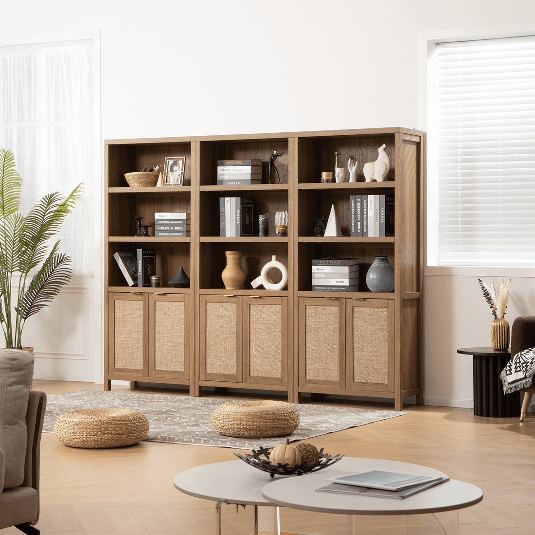 Three SICOTAS Savanna Book Case Decorated with Books, Vases, Candles, and Speakers in Modern Living Room with Plants, Sofa, Side Tables, a Rug with two Floor Seats, and a Coffee Table