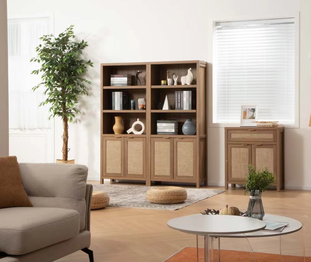 Two SICOTAS Savanna Bookcase Decorated With Books, Vases, and Candles and Savanna Buffet Cabinet with Drawer in a Farmhouse Style Living Room with Sofa with Brown Cushion, Plants, Orange Rug, Wooden Floor Tiling, and a Marble Coffee Table with Vases